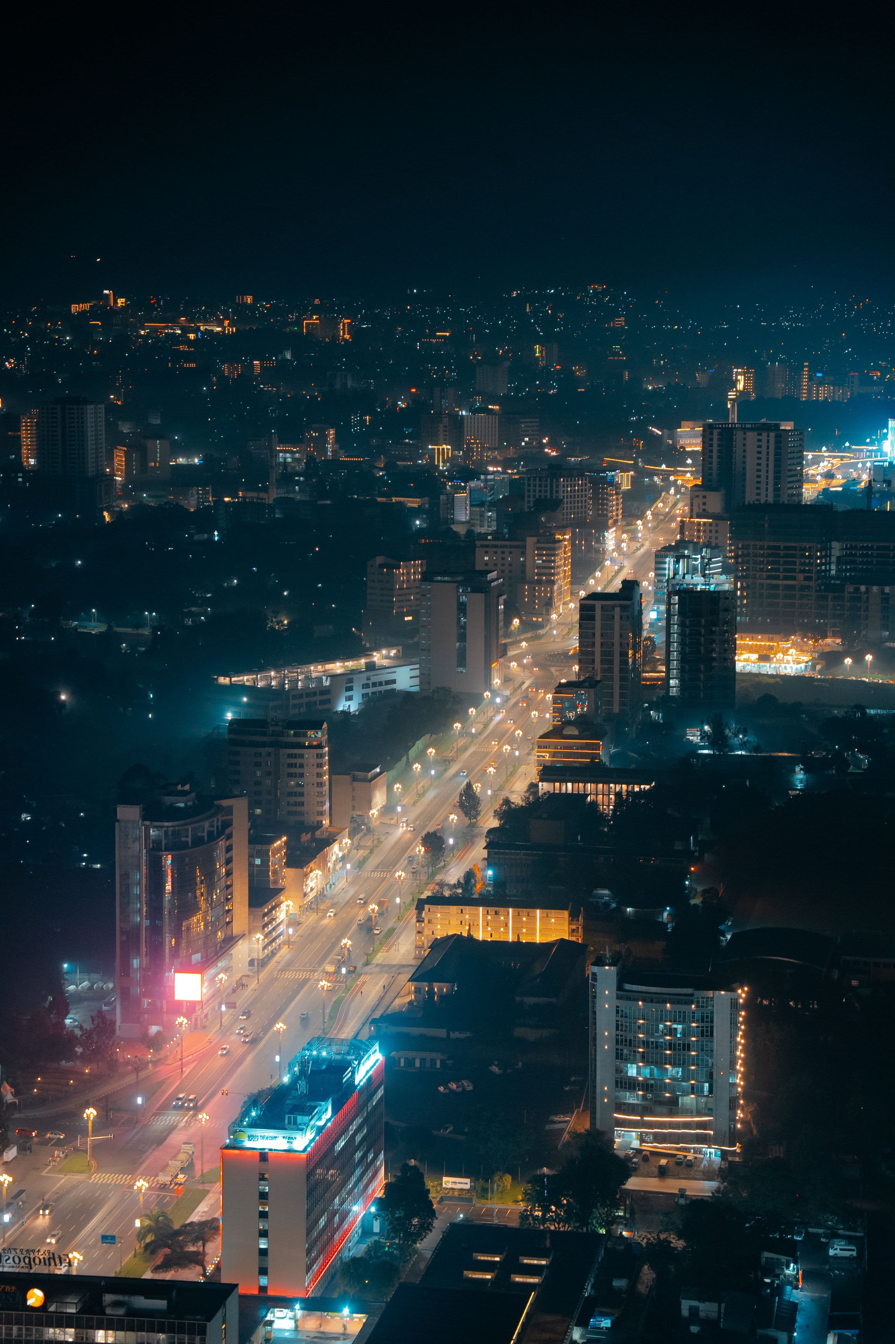 Addis Ababa at night, seen from above, with a brightly lit avenue running through the city.
